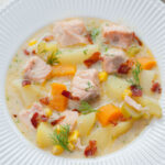 Salmon chowder in a white plate.