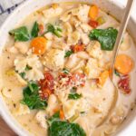 Tuscan chicken soup in a white bowl.