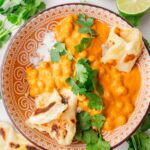 Chickpea curry with rice and pieces of Naan bread in a brown bowl.