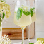 Two glasses with hugo cocktail. Elderflowers in the background.