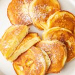 Apple ring pancakes on a beige plate.