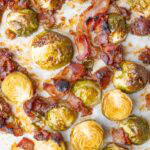 Roasted Brussels sprouts with bacon on a baking sheet.